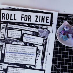 A Roll For Zine game sheet and a set of die