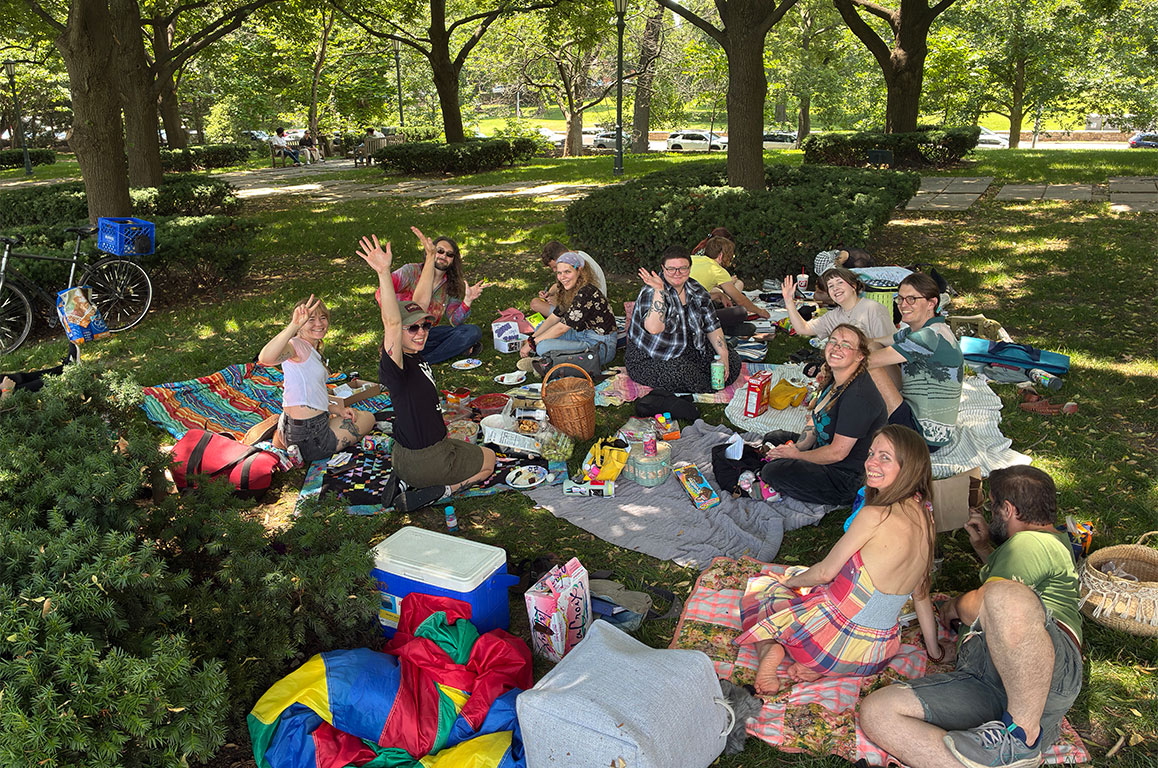 A bunch of zinesters at a pinic, smiling for the camera