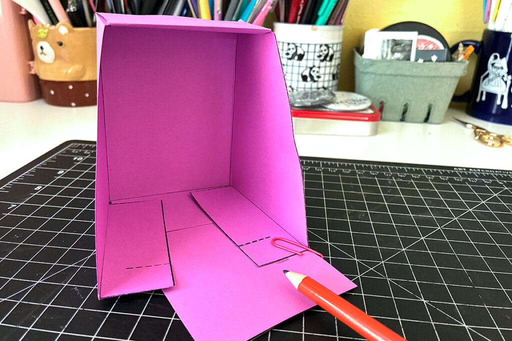 A paper zine holder folded together.